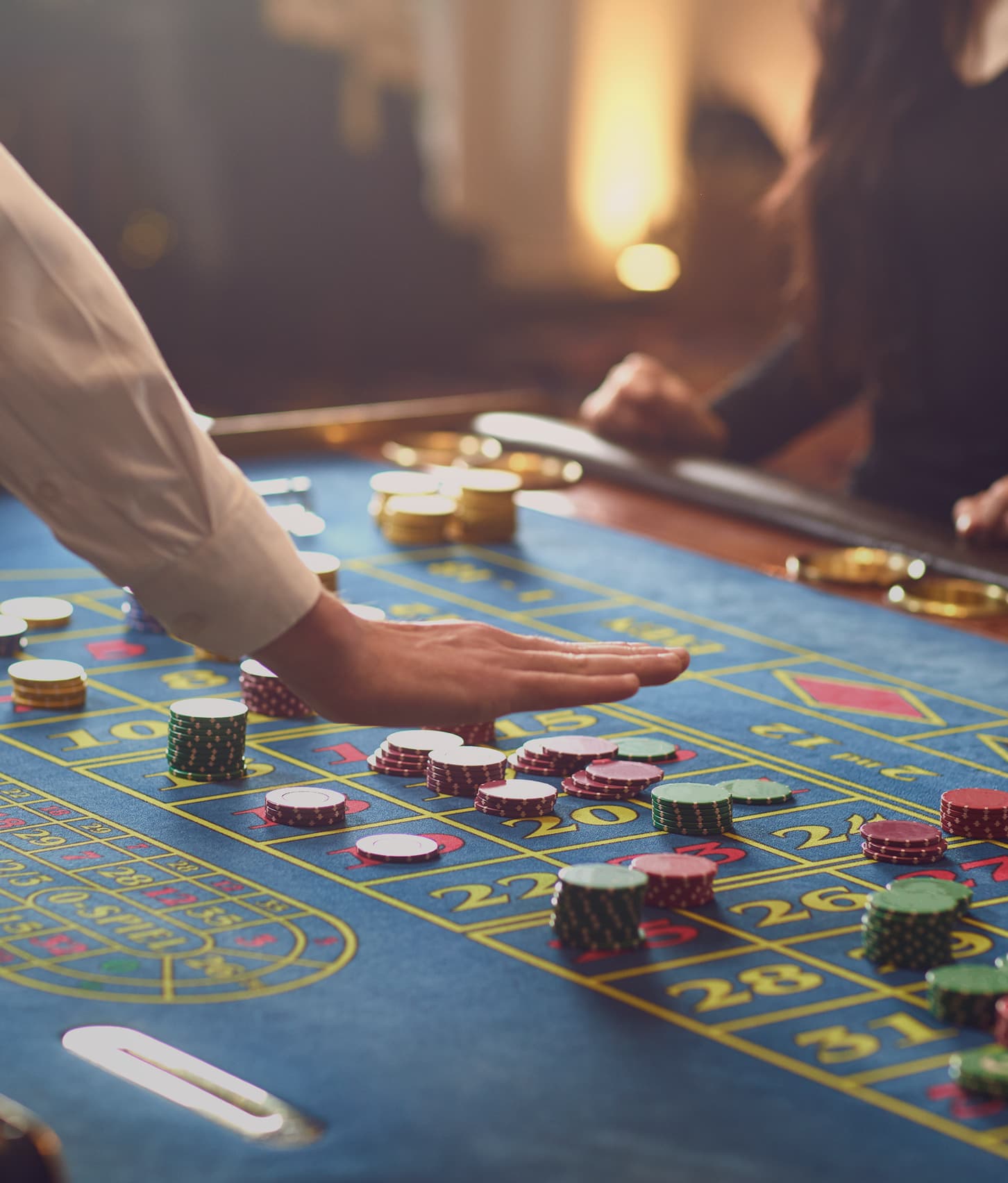 A croupier’s hand over the chips on a roulette table