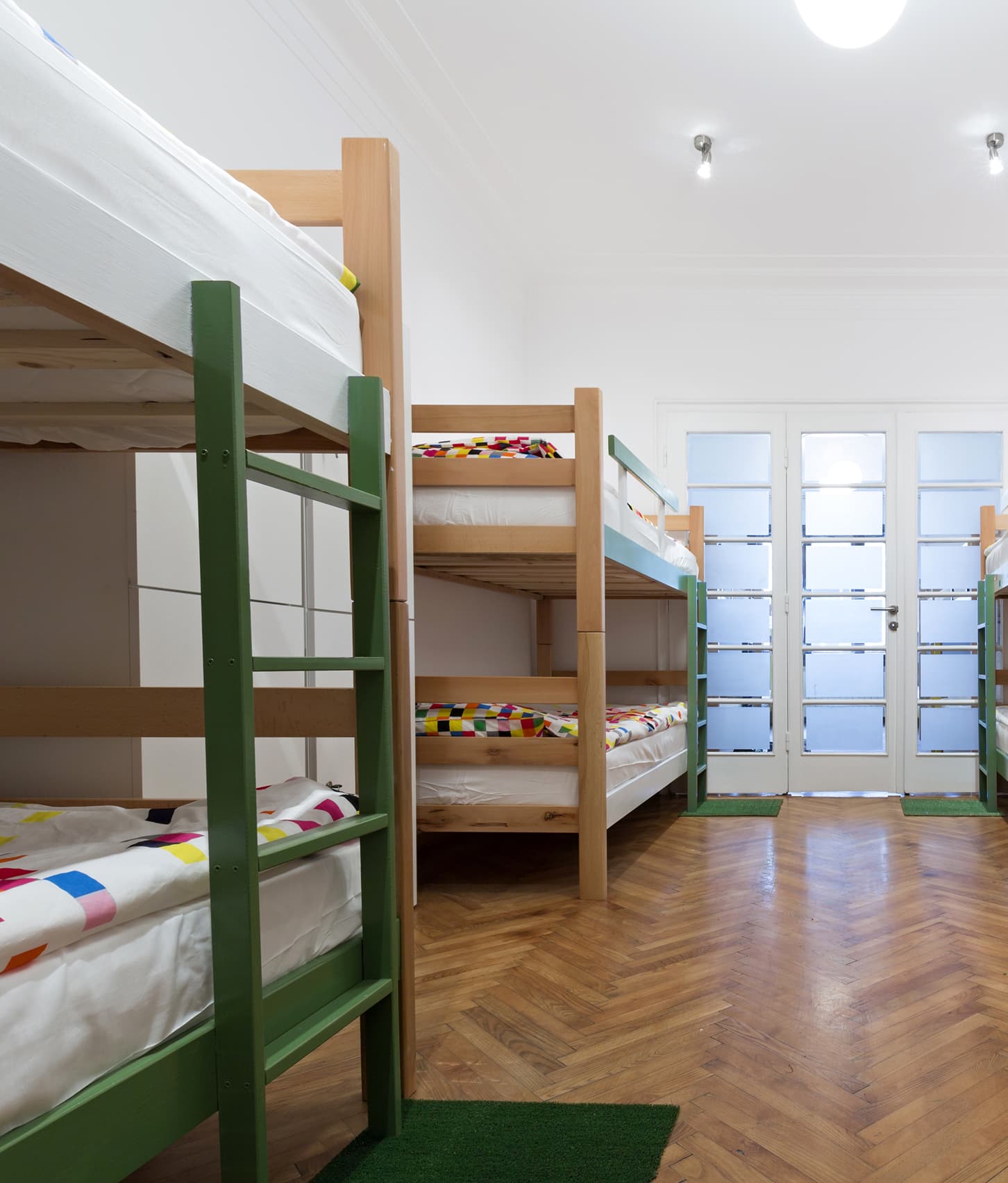Wooden bunk beds in a bright hostel dormitory