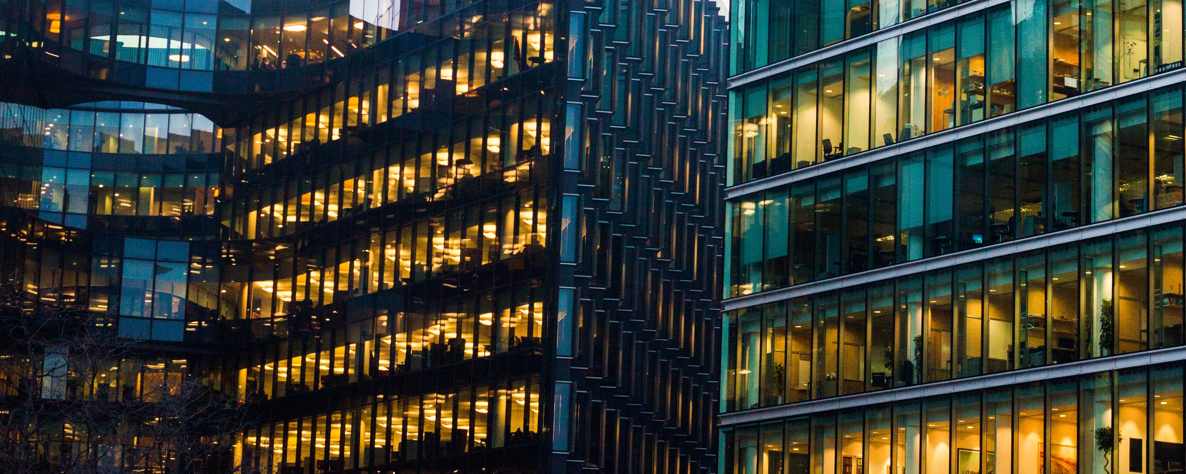 An office block at night, its windows lit gold