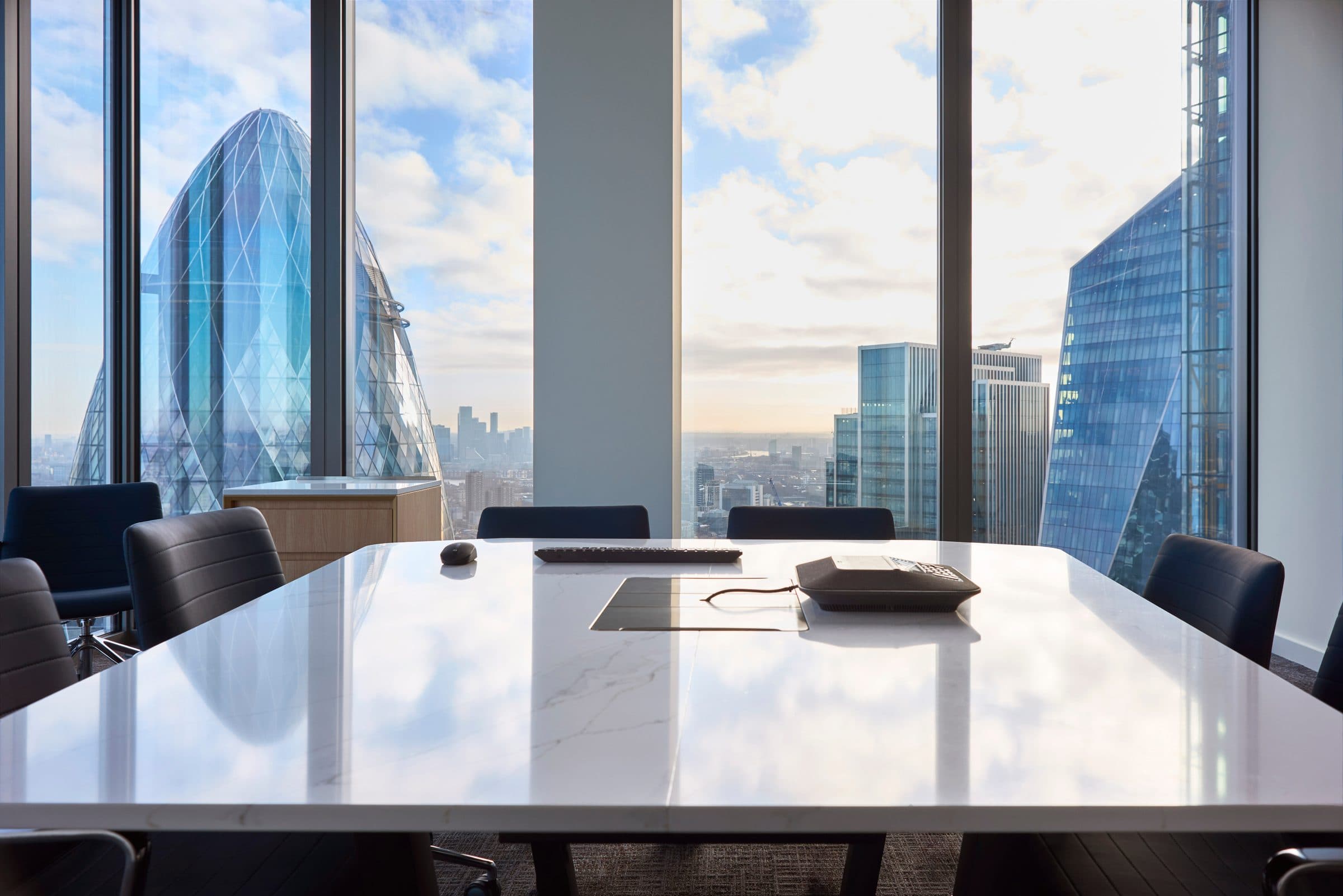 An empty boardroom table with city views