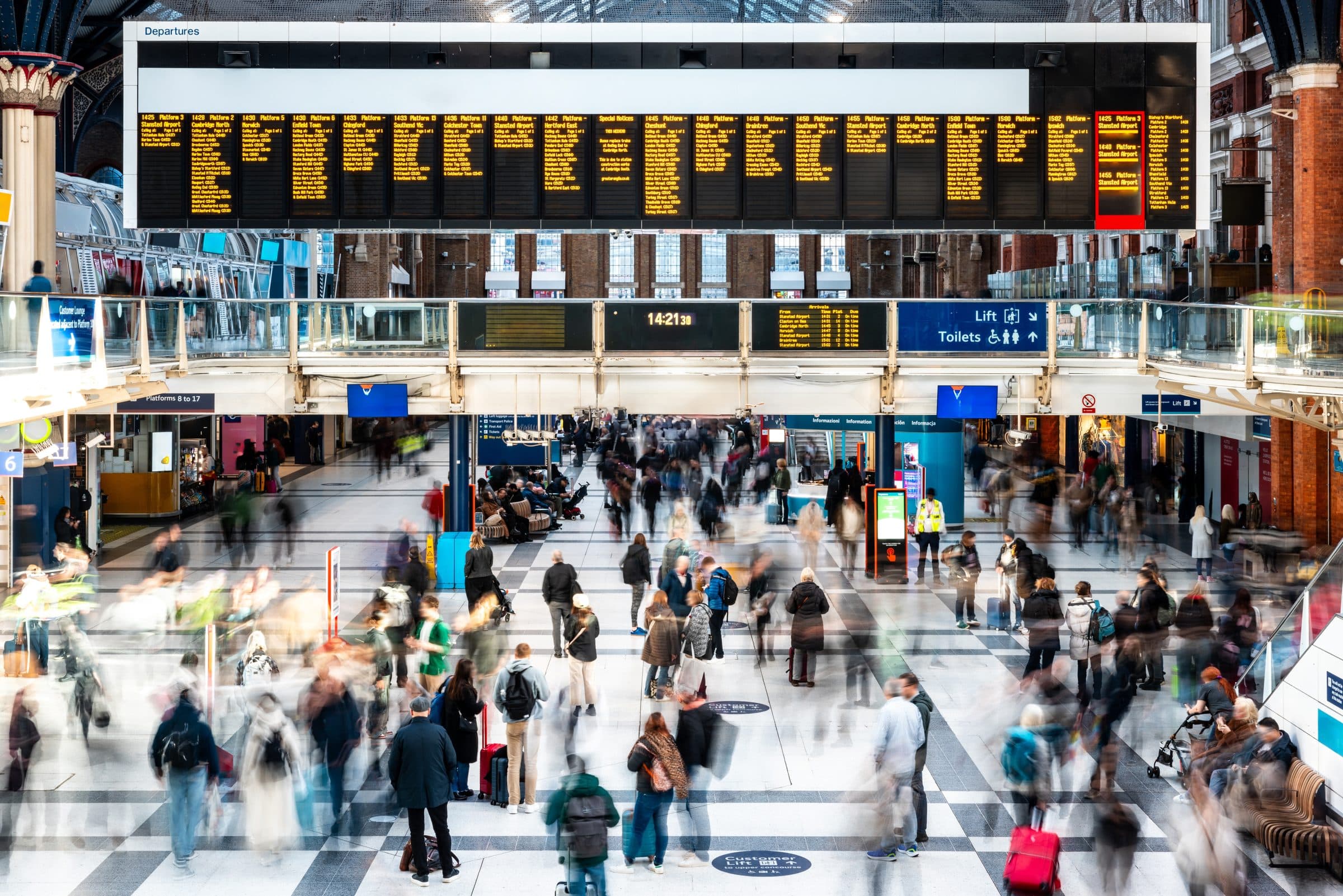 Crowds crossing a railway station concourse